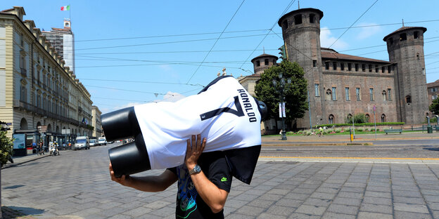 Ein Mann trägt eine Schaufensterpuppe mit einem Trikot von Juve und Ronaldos Namen durch die Straßen von Turin Ein Mann trägt eine Schaufensterpuppe mit einem Trikot von Juve und Ronaldos Namen durch die Straßen von Turin