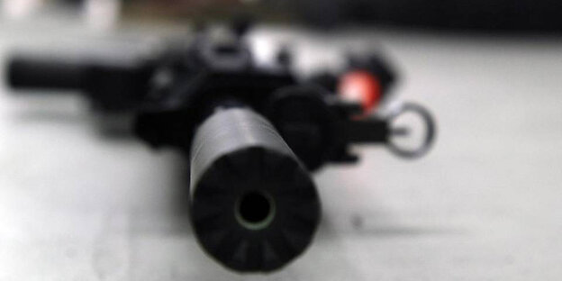 Ein Maschinengewehr mit Zielrohr liegt auf einem Tisch Ein Maschinengewehr mit Zielrohr liegt auf einem Tisch