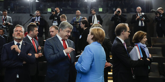 Petro Poroschenko, Präsident der Ukraine, und Bundeskanzlerin Angela Merkel (CDU, r) unterhalten sich zu Beginn der Arbeitssitzung des Nordatlantikrates beim Nato-Gipfel. Petro Poroschenko, Präsident der Ukraine, und Bundeskanzlerin Angela Merkel (CDU, r) unterhalten sich zu Beginn der Arbeitssitzung des Nordatlantikrates beim Nato-Gipfel.