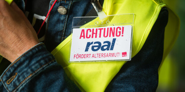 Eine Beschäftigte von Real trägt ein Schild, das vor Armut im Alter warnt Eine Beschäftigte von Real trägt ein Schild, das vor Armut im Alter warnt