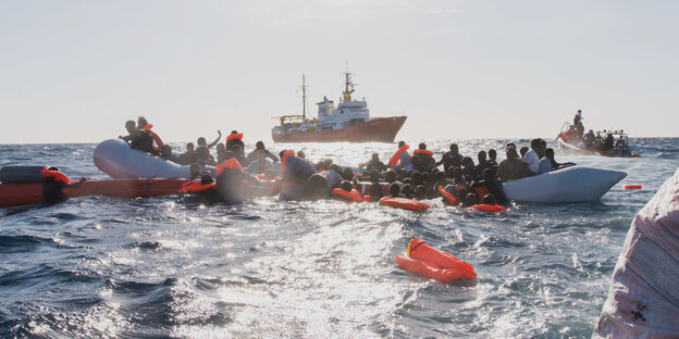Zahlreiche Flüchtlinge, die auf Booten von Libyen aus nach Italien übersetzen wollten, werden während eines Rettungseinsatzes geborgen. Zahlreiche Flüchtlinge, die auf Booten von Libyen aus nach Italien übersetzen wollten, werden während eines Rettungseinsatzes geborgen.
