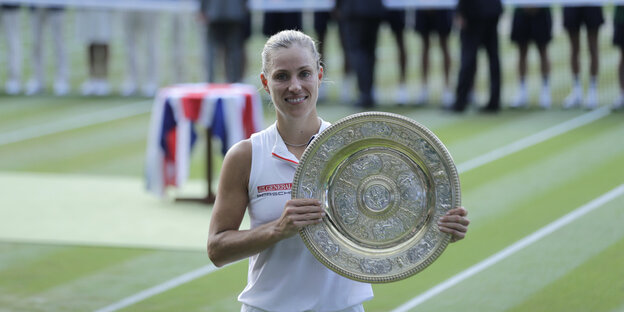 Die Tennisspielerin Angélique Kerber mit der Siegerinnenschale von Wimbledon - sie lächelt glücklich Die Tennisspielerin Angélique Kerber mit der Siegerinnenschale von Wimbledon - sie lächelt glücklich