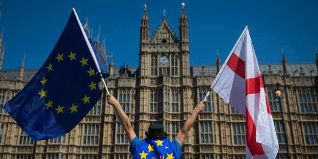 Ein Anti-Brexit-Demonstrant hält eine europäische und eine englische Flagge Ein Anti-Brexit-Demonstrant hält eine europäische und eine englische Flagge