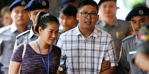 Der inhaftierte Reuters-Journalist Wa Lone läuft mit seiner Frau Pen Ei Mon in Polizeibegleitung zum Gericht Der inhaftierte Reuters-Journalist Wa Lone läuft mit seiner Frau Pen Ei Mon in Polizeibegleitung zum Gericht