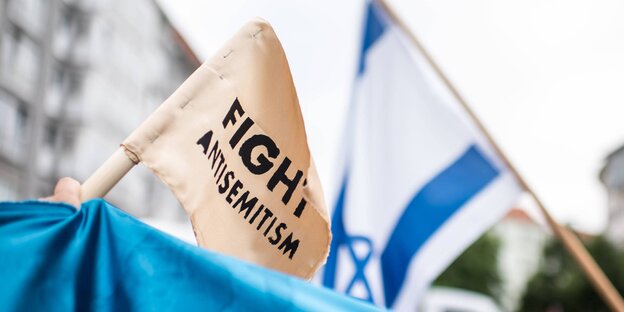 Eine Israel-Flagge und eine weiße Flagge, auf der "Fight Antisemitism" steht Eine Israel-Flagge und eine weiße Flagge, auf der "Fight Antisemitism" steht