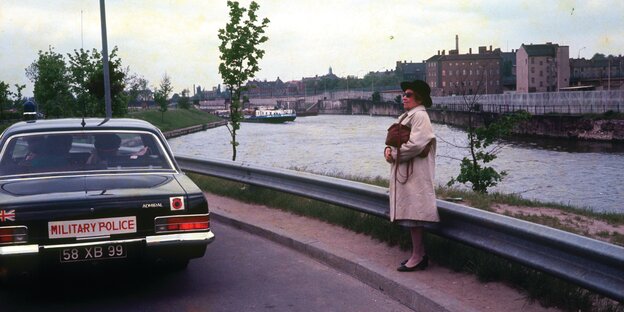 Eine Frau steht vor einem Fluss Eine Frau steht vor einem Fluss