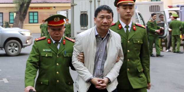Der angeklagte Geschäftsmann Trinh Xuan Thanh wird von Polizisten zu einem Gericht in Hanoi (Vietnam) gebracht Der angeklagte Geschäftsmann Trinh Xuan Thanh wird von Polizisten zu einem Gericht in Hanoi (Vietnam) gebracht