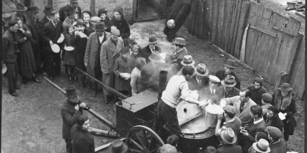 Menschen verteilen Essen aus einer Gulaschkanone Menschen verteilen Essen aus einer Gulaschkanone