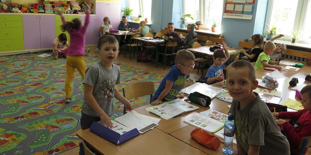Kinder sitzen und spielen in einem Klassenzimmer Kinder sitzen und spielen in einem Klassenzimmer
