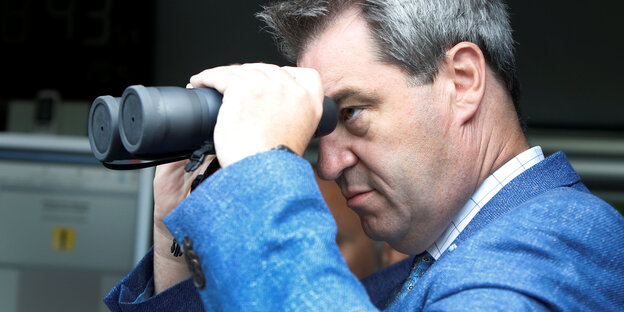 Markus Söder schaut durch ein Fernglas Markus Söder schaut durch ein Fernglas