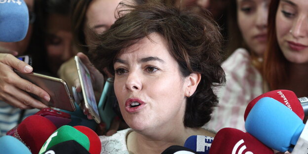 Eine Frau, Soraya Sáenz, Kandidatin für den Vorsitz der Partido Popular, spricht in die Mikrofone von Journalisten Eine Frau, Soraya Sáenz, Kandidatin für den Vorsitz der Partido Popular, spricht in die Mikrofone von Journalisten