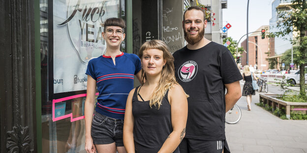 Zwei Frauen und ein Mann stehen vor dem Schaufenster ihres Sexshops. Zwei Frauen und ein Mann stehen vor dem Schaufenster ihres Sexshops.