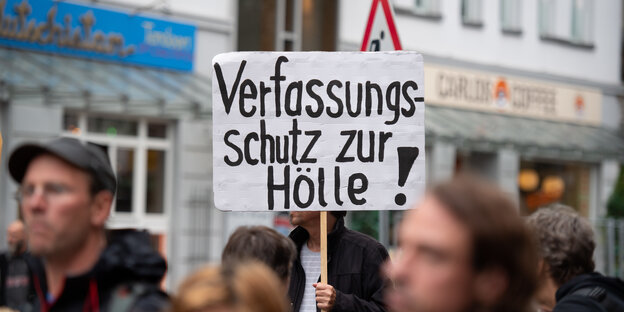 Ein Demonstrant trägt ein Schild mit der Aufschrift "Verfassungsschutz zur Hölle!". Ein Demonstrant trägt ein Schild mit der Aufschrift "Verfassungsschutz zur Hölle!".