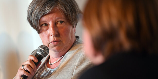 Senatorin Katrin Lompscher mit einem Mikrofon in der Hand im Gespräch mit einer Frau