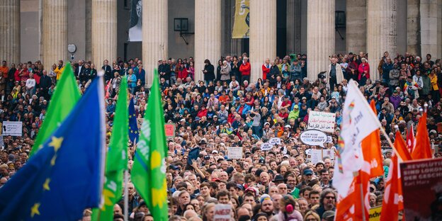 Menschen auf der Straße, ein Mann zeigt ein Peace-Zeichen