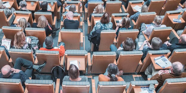 Menschen sitzen in einem Hörsaal Menschen sitzen in einem Hörsaal