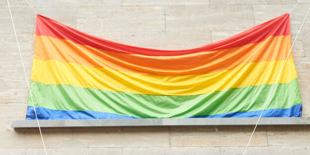 Regenbogenfahne an einer Häuserwand Regenbogenfahne an einer Häuserwand