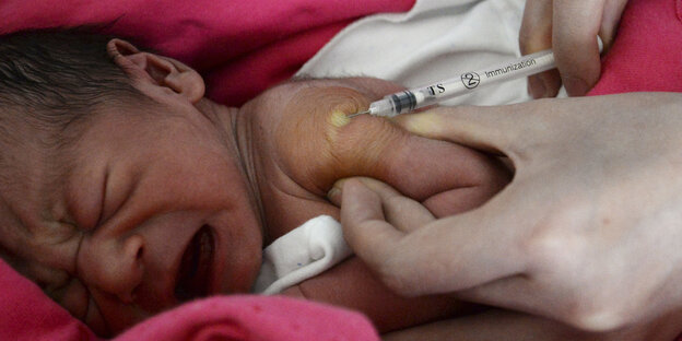 Baby wird mit einer Spritze in die Schulter geimpft Baby wird mit einer Spritze in die Schulter geimpft