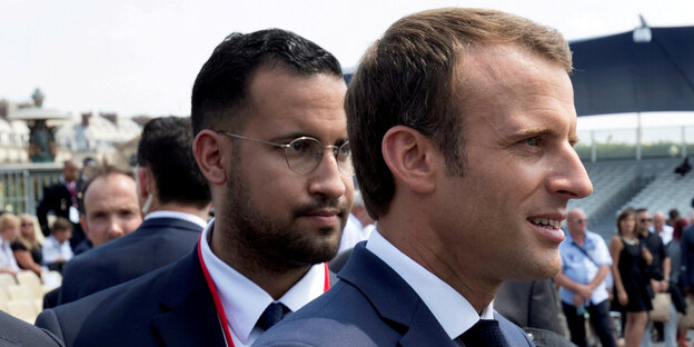 Ein Mann steht hinter einem anderen. Es sind Emmanuel Macron und sein Sicherheitsbegleiter Alexandre Benalla Ein Mann steht hinter einem anderen. Es sind Emmanuel Macron und sein Sicherheitsbegleiter Alexandre Benalla