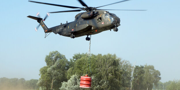 Ein Helikopter fliegt über ein Feld Ein Helikopter fliegt über ein Feld