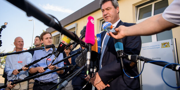 Ein Mann steht vor Mikrofonen. Es ist Markus Söder Ein Mann steht vor Mikrofonen. Es ist Markus Söder