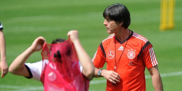 Mesut Özil zieht sich das Trikot aus, Jogi Löw schaut weg