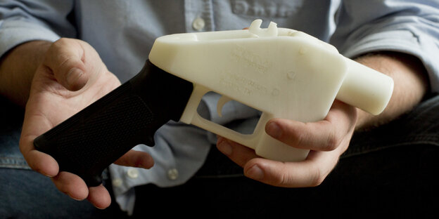 Eine Person hält eine Plastik-Pistole, die komplett im 3D-Drucker hergestellt wurde Eine Person hält eine Plastik-Pistole, die komplett im 3D-Drucker hergestellt wurde