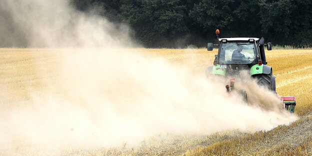 Traktor mit Egge fährt über ein Feld Traktor mit Egge fährt über ein Feld