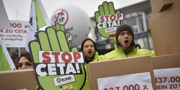 Protestaktion gegen CETA, Mehrere Menschen halten Plakate hoch Protestaktion gegen CETA, Mehrere Menschen halten Plakate hoch