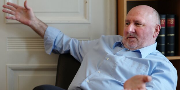Kurt Scheel, sitzend und mit den Armen gestikulierend Kurt Scheel, sitzend und mit den Armen gestikulierend