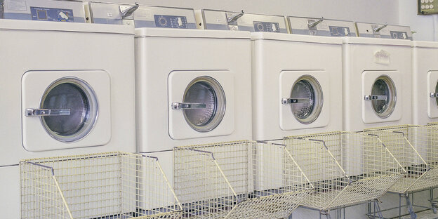 Ein Waschsalon, viele weiße Waschmaschinen Ein Waschsalon, viele weiße Waschmaschinen