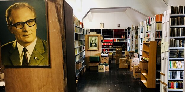 Eine Bibliothek mit gestapelten Bananenkisten und einem Honecker-Bild an der Wand Eine Bibliothek mit gestapelten Bananenkisten und einem Honecker-Bild an der Wand