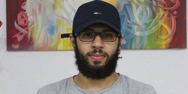 Ein junger Mann im grauen T-Shirt und schwarzem Käppi Ein junger Mann im grauen T-Shirt und schwarzem Käppi