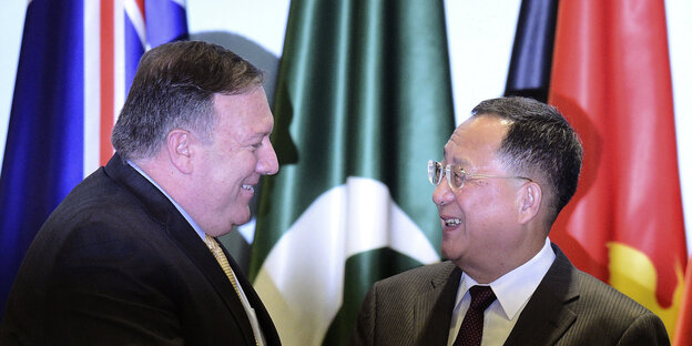 Mike Pompeo, Außenminister der USA, begrüßt Ri Young Ho, Außenminister von Nordkorea, während sie sich für ein Gruppenfoto im Rahmen des 51. ASEAN-Außenministertreffens aufstellen Mike Pompeo, Außenminister der USA, begrüßt Ri Young Ho, Außenminister von Nordkorea, während sie sich für ein Gruppenfoto im Rahmen des 51. ASEAN-Außenministertreffens aufstellen