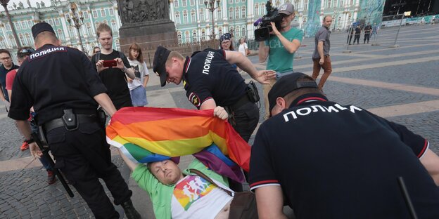 Polizisten tragen einen LGBT-Aktivisten weg Polizisten tragen einen LGBT-Aktivisten weg