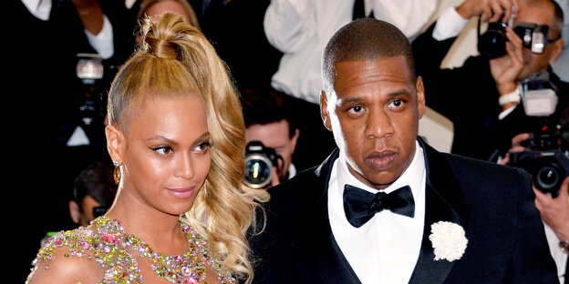 Beyonce und Jay Z in Abendgarderobe, umgeben von Fotografen Beyonce und Jay Z in Abendgarderobe, umgeben von Fotografen