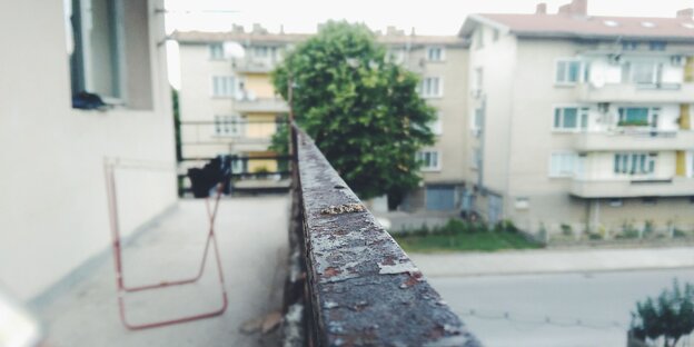 Die vermoderte Brüstung eines Balkons in einem tristen Wohnviertel Die vermoderte Brüstung eines Balkons in einem tristen Wohnviertel
