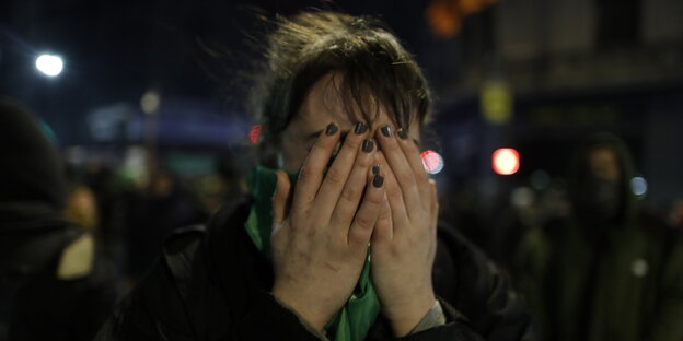 Eine Demonstrantin schlägt sich die Hände vor dem Gesicht zusammen Eine Demonstrantin schlägt sich die Hände vor dem Gesicht zusammen