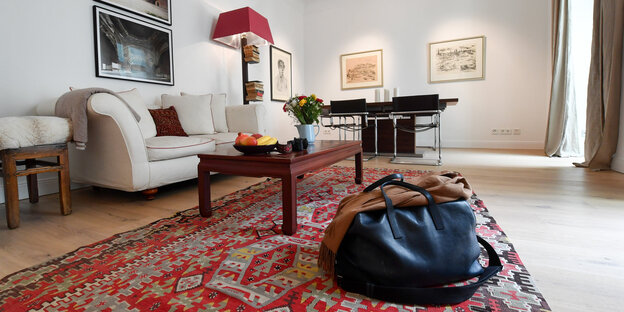 Wohnzimmer mit Reisetasche auf einem Teppich Wohnzimmer mit Reisetasche auf einem Teppich