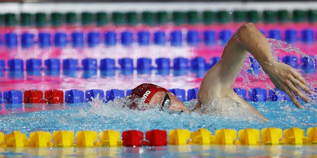 Ein Schwimmer zieht in einem Becken seinen Bahnen Ein Schwimmer zieht in einem Becken seinen Bahnen