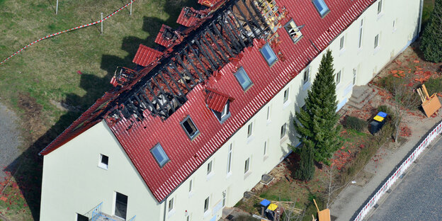 Ein großes Wohnhaus von oben mit ausgebrannten Dachstuhl Ein großes Wohnhaus von oben mit ausgebrannten Dachstuhl