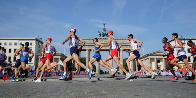 Viele Männer laufen vor dem Brandenburger Tor in Berlin Viele Männer laufen vor dem Brandenburger Tor in Berlin