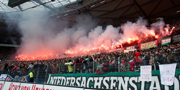 Im Fanblock eines Fußballstadions brennen mehrere Bengalos. Im Fanblock eines Fußballstadions brennen mehrere Bengalos.