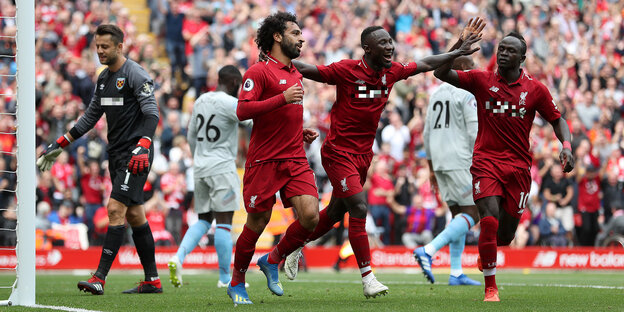 Mo Salah (links) und Naby Keita (Mitte)laufen beim 4:0-Triumph gegen West Ham.über den Rasen, reißen die Arme hoch und jubeln über ein Tor Mo Salah (links) und Naby Keita (Mitte)laufen beim 4:0-Triumph gegen West Ham.über den Rasen, reißen die Arme hoch und jubeln über ein Tor