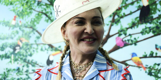 US-Sängerin Madonna trägt einen Hut vor einer Leinwand mit einem Baum- und Vogelmotiv US-Sängerin Madonna trägt einen Hut vor einer Leinwand mit einem Baum- und Vogelmotiv