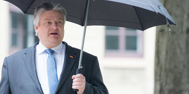 Ein Mann unter einem Regenschirm Ein Mann unter einem Regenschirm