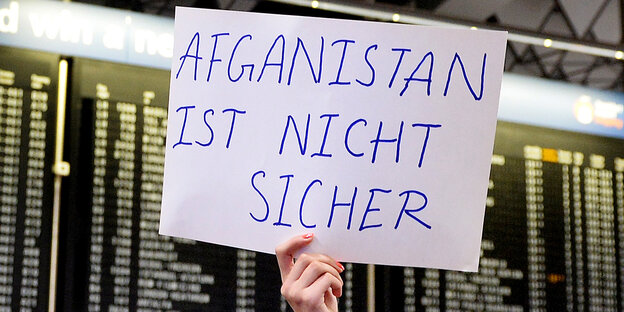 Schild "Afghanistan ist nicht sicher" vor Fluganzeige Schild "Afghanistan ist nicht sicher" vor Fluganzeige