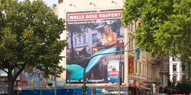 Ein Astra-Werbeplakat mit einem grinsenden Inder im Seejungfrauenkostüm. Ein Astra-Werbeplakat mit einem grinsenden Inder im Seejungfrauenkostüm.