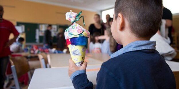 Junge mit Schultüte von hinten Junge mit Schultüte von hinten