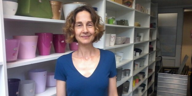 Mittelalte Frau vor einem weißen Regal Mittelalte Frau vor einem weißen Regal
